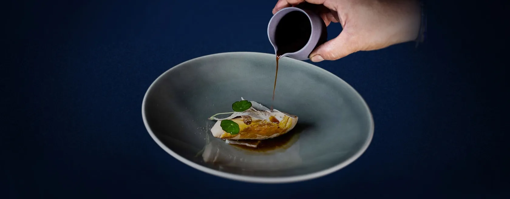 Le chef nappant de sauce une assiette gastronomique au restaurant de Luzy (58)
