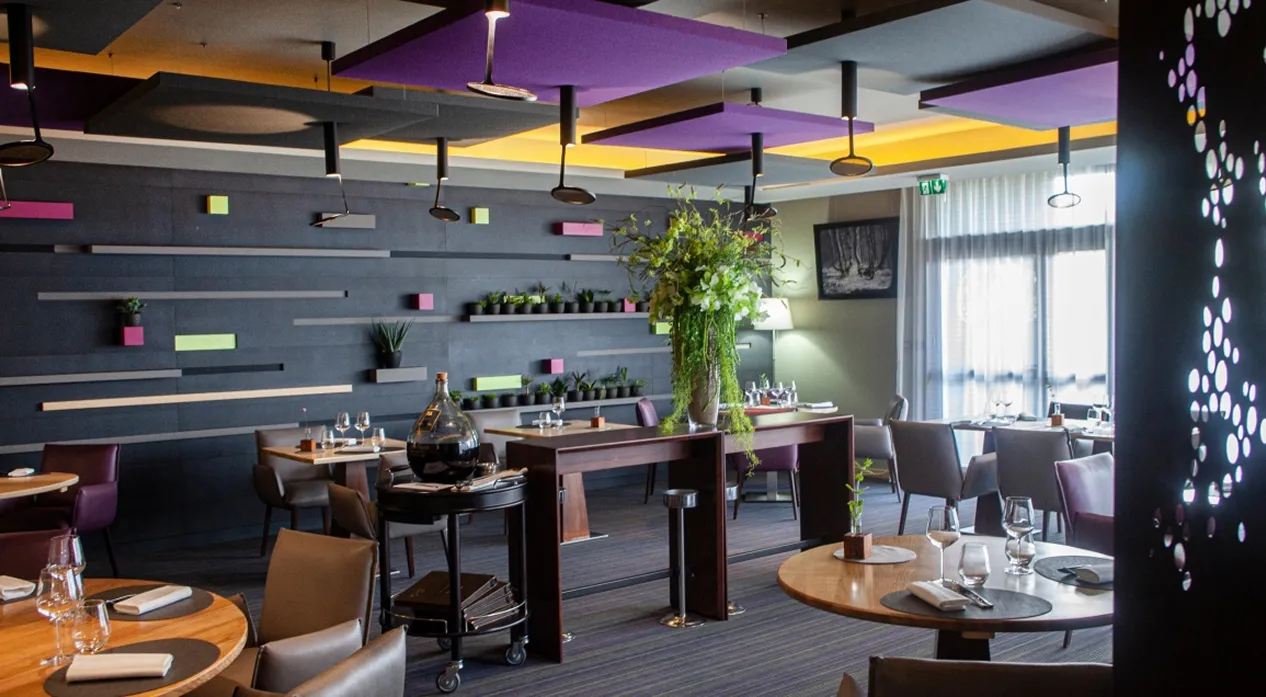 Salle du restaurant La Table de Jérôme à Luzy, murs noirs, touches de couleurs vives et plafonds violets